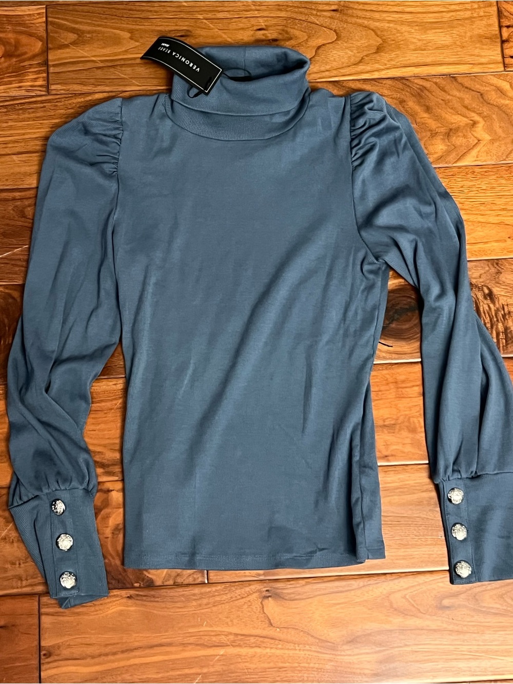 Brand new Blue Turtleneck Top with ruffle shoulder detail and silver buttons